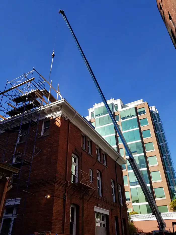 Crane boom over a heritage brick building