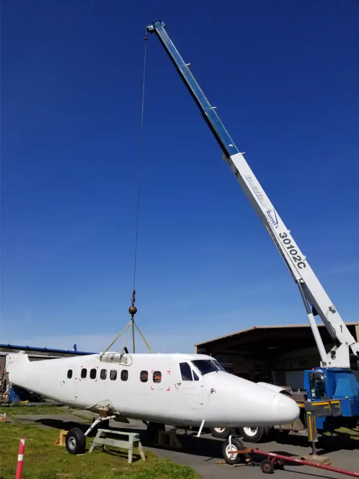 Crane lifting a small aircraft