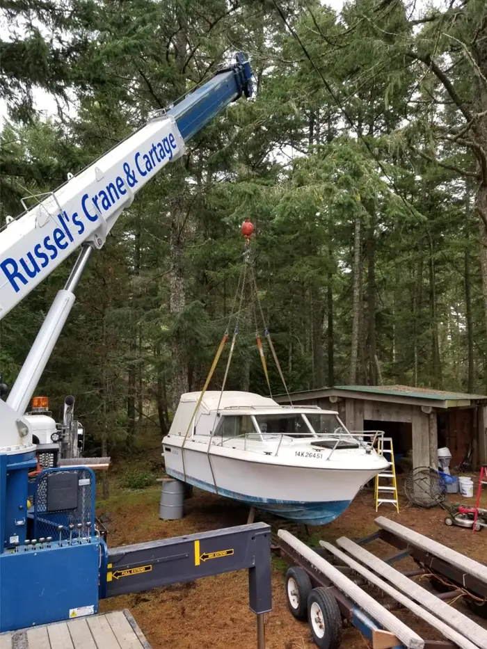 Crane lifting a boat from the water's edge