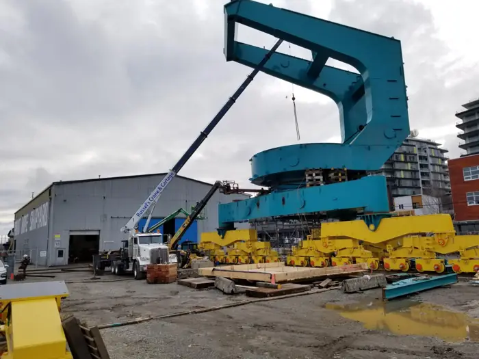 Crane placing a large teal public art sculpture