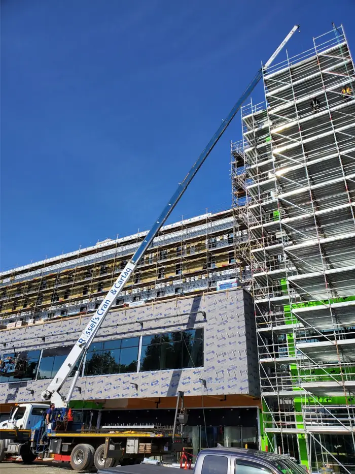 Crane lifting next to a high-rise under construction