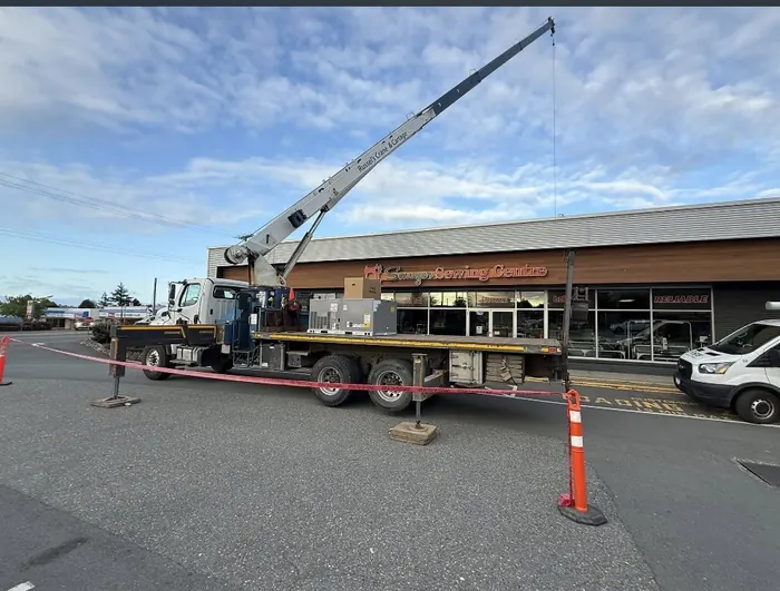 Crane lifting a rooftop HVAC unit onto Sawyer Sewing Centre