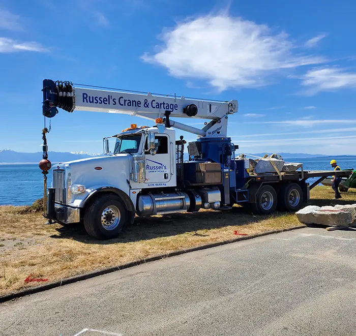Russel's Crane & Cartage crane truck parked by the ocean